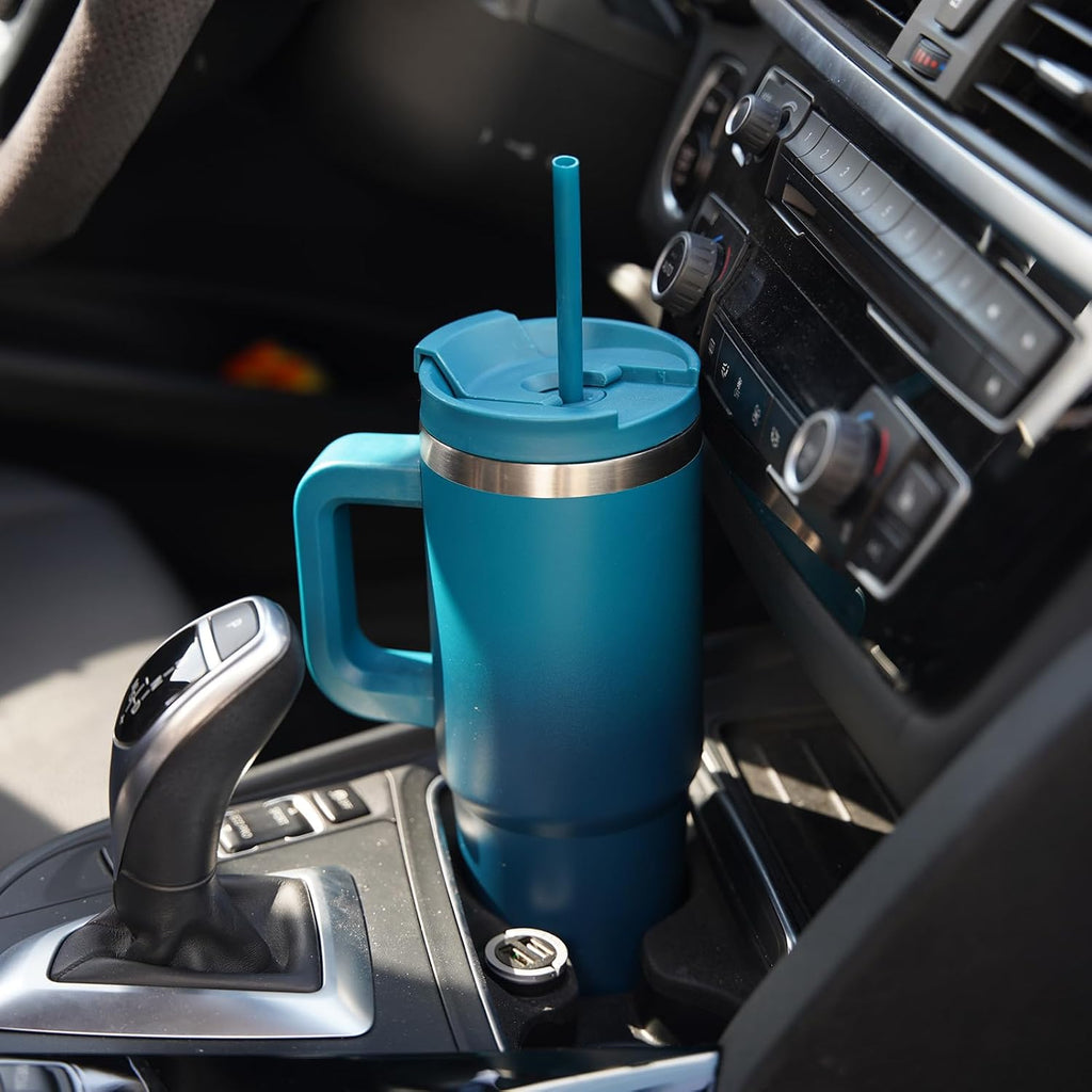 Blue insulated mug with a straw in a car cup holder