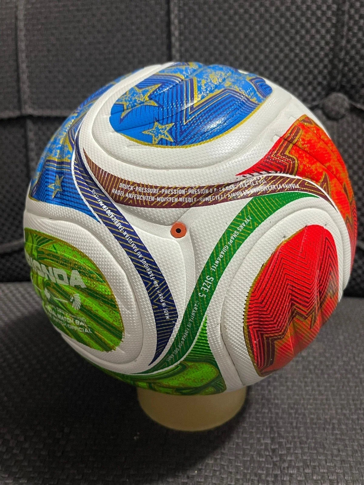 Colorful soccer ball with various symbols on a gray surface