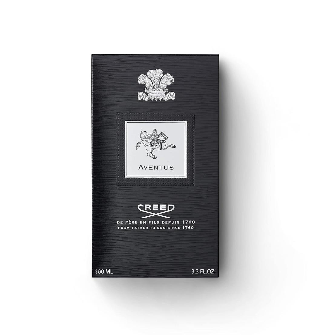 Creed Aventus 100ml box packaging, featuring a textured black background with a silver crest and logo details, set against a plain white background.