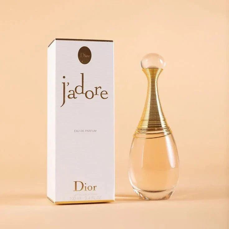 Dior j'adore perfume bottle and packaging on a beige background