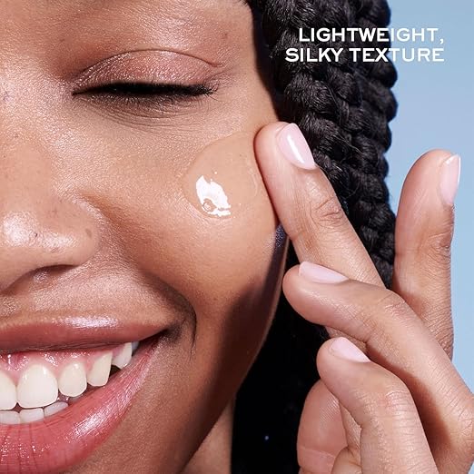 Close-up of a smiling woman applying a glossy cream product to her cheek, with braided hair and a blue background. White text in the top right reads 'LIGHTWEIGHT, SILKY TEXTURE'.