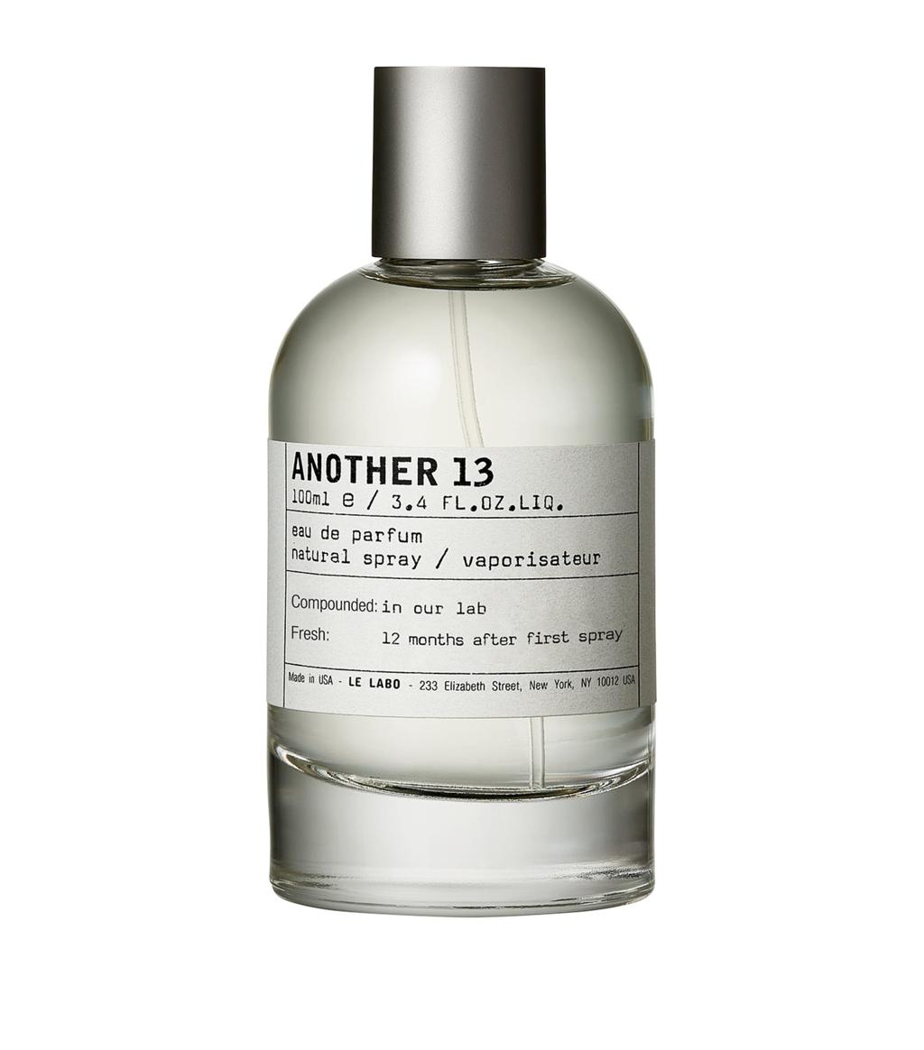 A 100ml bottle of ANOTHER 13 Eau de Parfum with a clear glass body, light-colored liquid, a white label with black text, and a metallic silver cap, shown on a plain white background.