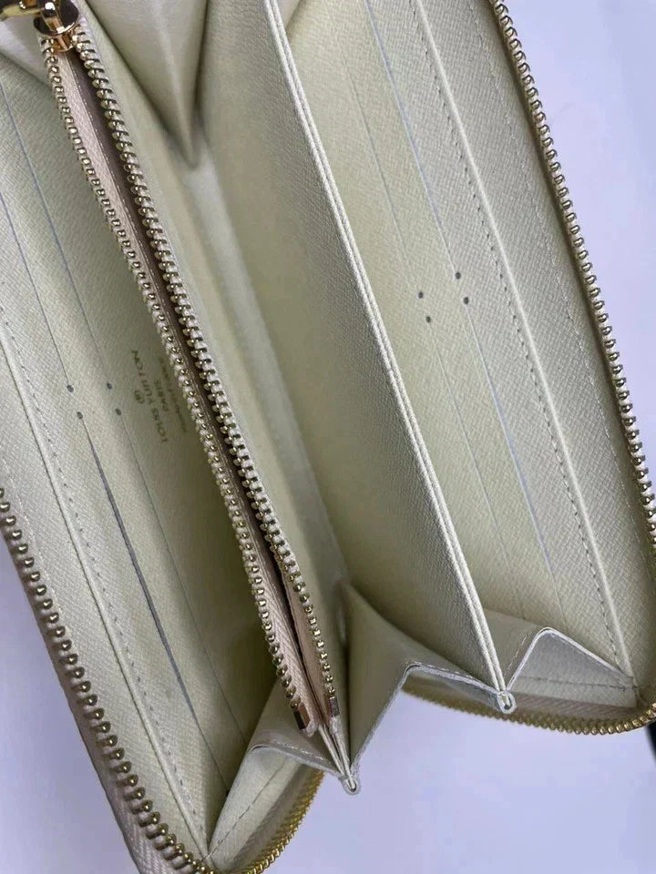 Close-up of a beige wallet with gold zipper on a white background