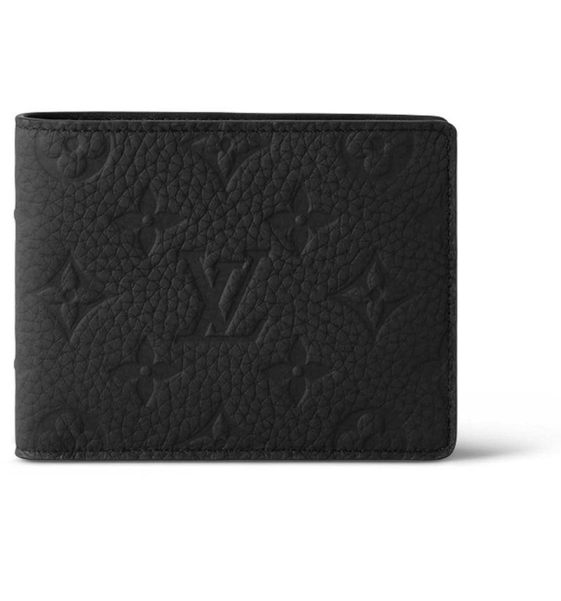A black textured leather bifold wallet with an embossed Louis Vuitton monogram pattern, shown on a clean white background.