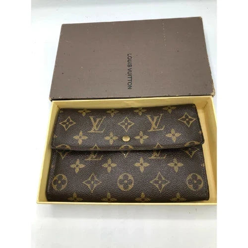Louis Vuitton monogram wallet in brown coated canvas with gold-tone hardware, displayed inside an open Louis Vuitton box on a white background.