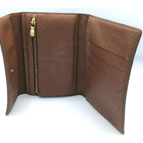 Brown wallet with a gold zipper on a white background