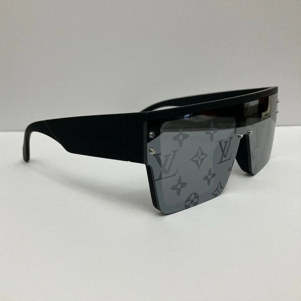 Louis Vuitton oversized shield sunglasses with a matte black frame and gray monogram-patterned lenses, shown on a light gray background.