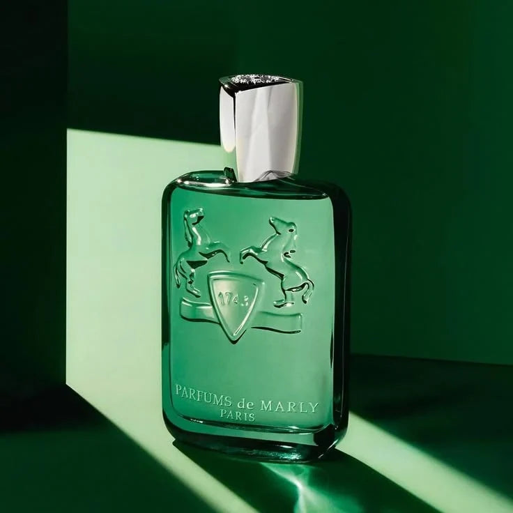 Green perfume bottle with silver cap on a green background