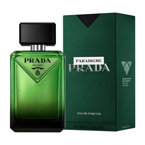 Prada Paradigme Milano Eau de Parfum bottle in green glass next to its textured dark green packaging box on a white background.