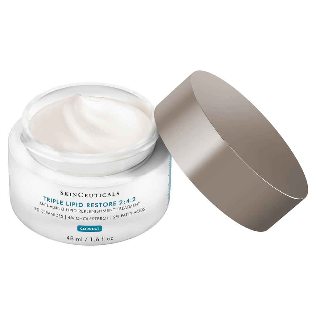 SkinCeuticals Triple Lipid Restore 2:4:2 cream in a clear jar with its metallic taupe lid resting beside it on a white background.
