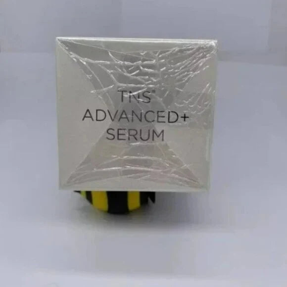 A square white skincare serum box wrapped in clear plastic, with the text 'TNS ADVANCED+ SERUM' visible on the front, set against a plain light background.