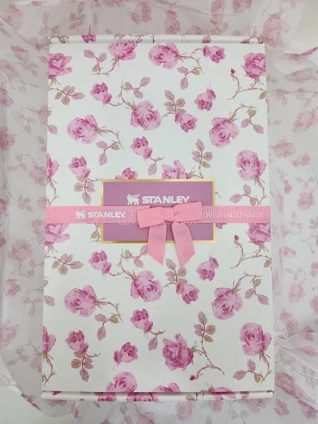 Floral-patterned box with a pink bow and 'Stanley' label on a matching floral background.
