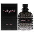 Valentino Uomo Born in Roma fragrance shown with its black textured box and the bottle itself. The bottle is made of faceted dark gray glass with a black cap and a black label featuring pink lettering.