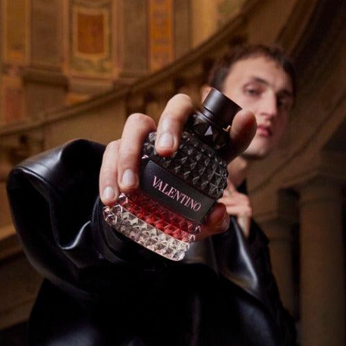 Person holding a Valentina perfume bottle in an indoor setting