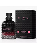 Valentino Uomo Born in Roma Intense Eau de Parfum Intense bottle with a textured black cap and base, showing a deep red liquid inside, next to its black geometric packaging box with pink lettering.