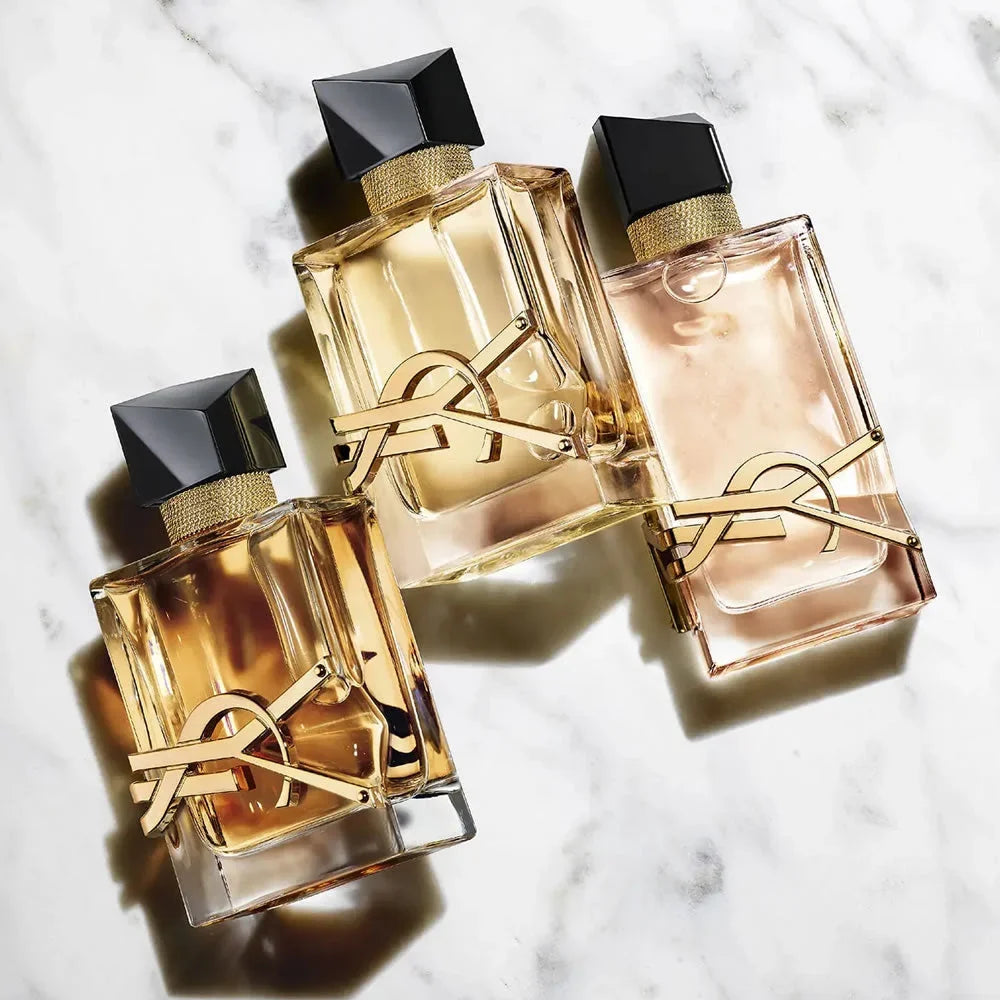 Three YSL perfume bottles on a marble surface